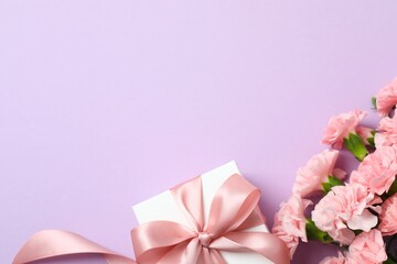 Beautiful bouquet of pink carnations with gift box on white background