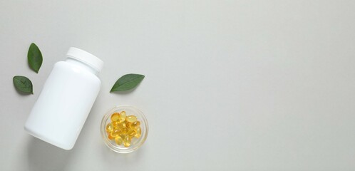 White bottle on a gray background. Fish oil tablets. Biologically active additives. Omega 3, 6, omega 9, vitamin A, E, D