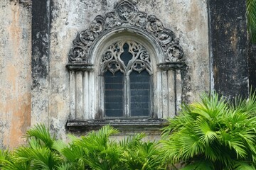 Obraz premium Ornate Historic Church Facade with Weathered Stone and Tropical Plants