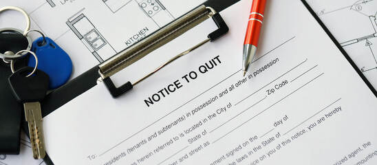 Pen and keys on Notice to quit form and planning blueprints of residential building project close up