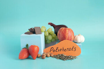 Products containing a lot of polyphenols in their composition. Grapes, onions, garlic, chocolate, tea, nuts, apple, strawberries, close-up on a light background and the inscription "polyphenols"