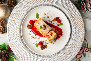 White chocolate brownie with walnuts and raspberries top view table with christmas decorations.