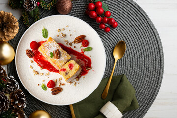 White chocolate brownie with walnuts and raspberries top view table with christmas decorations.