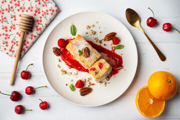 White chocolate brownie with walnuts and raspberries top view table.