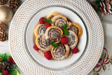 Puff pastry rolls filled with Nutella and pistachios. Top view table with christmas decorations.