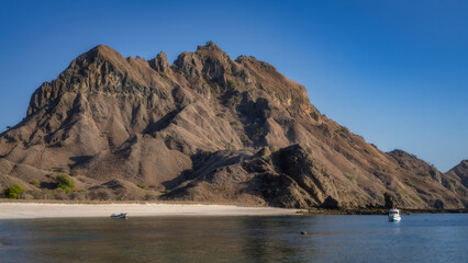 A stunning view of a rugged mountain above clear waters creates a tranquil beach setting, inviting relaxation and exploration for all nature enthusiasts, Padar, Komodo, Indonesia