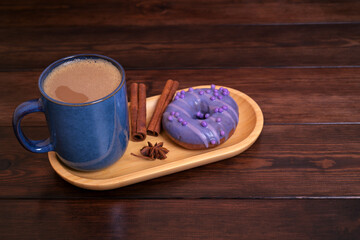 Blue Mug of Coffee and Purple Donut with Cinnamon on Wooden Tray