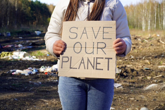 Environmental activist holding save our planet sign in polluted area