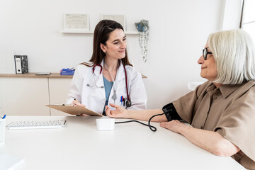 Doctor monitoring patient's blood pressure during a consultation in a medical office