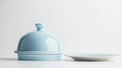 Fototapeta premium Light blue pastel serving cloche above empty plate on white background.