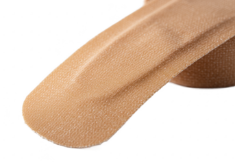 Close up of a beige bandage with a black background in studio shot