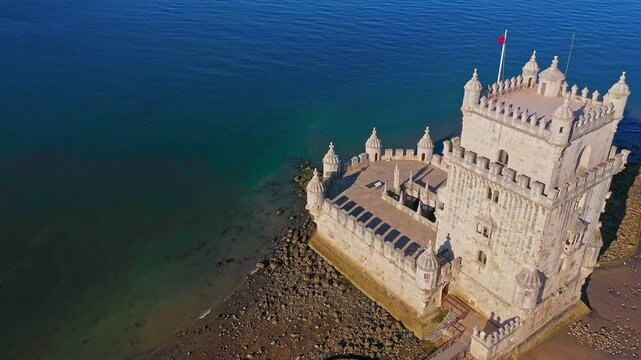 Drone tilt and track Belem tower, Lisbon, Portugal on sunny day 