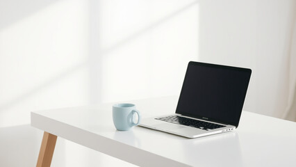 Minimalist workspace featuring a laptop and a coffee mug on a clean white desk with soft light