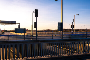 Urban infrastructure with metal railings and lampposts at sunset in Copenhagen, Denmark. Modern city design with clear blue sky and golden hour lighting, ideal for transportation concepts.