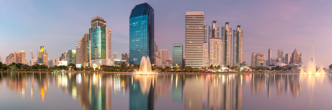 Panoramic view of Benjakitti Park with skyline and water fountain in Bangkok, Thailand