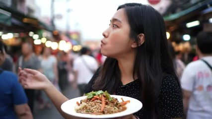 A young woman tastes flavorful street food at a bustling night market in Thailand. The lively environment features colorful stalls and a variety of delightful dishes being served. - Powered by Adobe