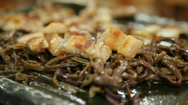 Grilled pork belly on top of bracken fern