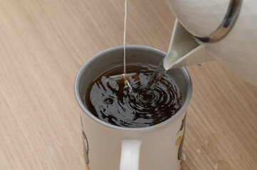 Zbliżenie na herbatę ekspresowa w torebce zalewana wrzącą woda w porcelanowym kubku 