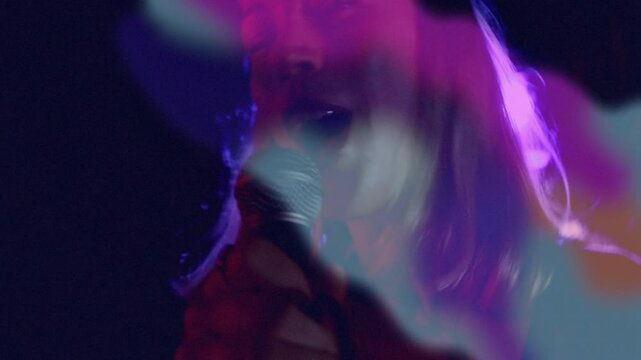 female singer singing on live music stage, with animated soundwave bars floating around mic