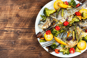 Roasted dorada fish with vegetables.