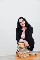 business woman teacher and stacks of educational books on table
