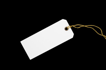 Blank paper label with cord isolated on black background. Close up of blank price label isolated.