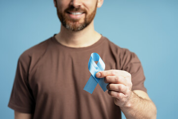 Man showing blue ribbon for prostate cancer awareness month