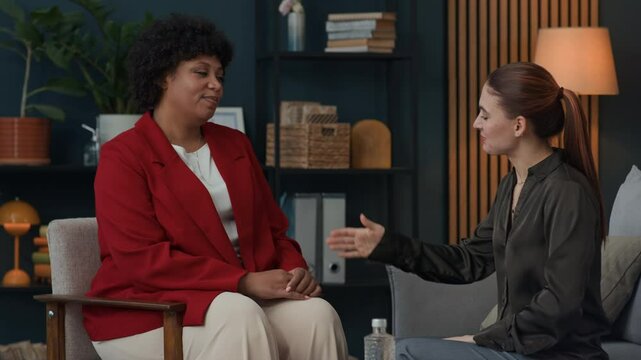 Medium long shot of female Caucasian client thanking African American psychologist after session