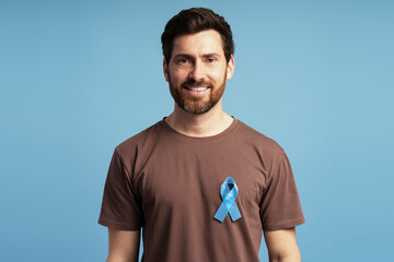 Man Smiling and Showing Blue Ribbon for Prostate Cancer Awareness Month