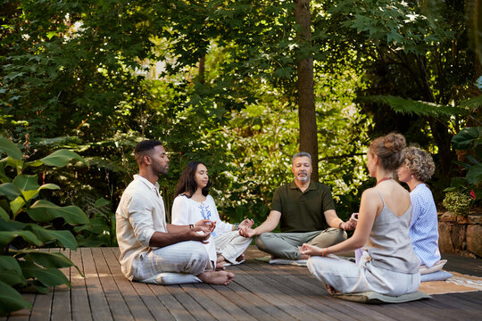 Multiethnic group of people meditating outdoor