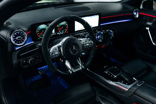 Interior view of Mercedes-Benz CLA 45 S AMG C118 with illuminated dashboard and ambient lighting premium black leather seats, digital cockpit, and modern design for luxury driving experience showcase