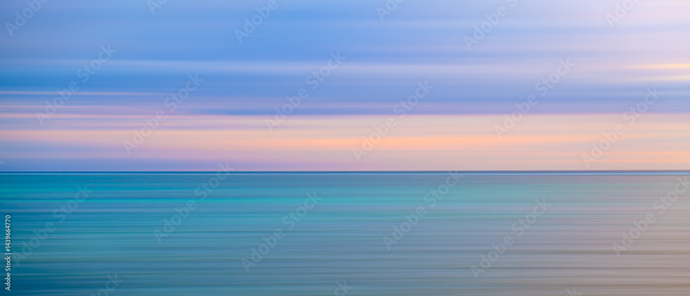 Poster the image is a blurry depiction of a calm ocean with a pink sky. the water appears to be a deep blue