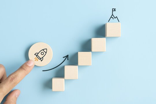 Reaching the Summit: Conceptual visual of a rocket launch on a path towards a mountain peak on a light blue background.