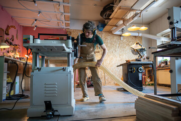 Meticulous joiner attach industrial vacuum hose to planer for clean workspace during woodworking. Planing machine runs efficiently while sawdust is directed into vacuum system, project readiness