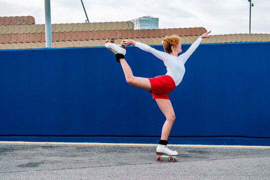 Woman performing an arabesque on roller skates outdoors