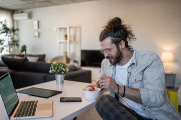 Freelancer enjoying healthy breakfast while working from home