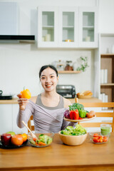  Young female in kitchen and writing down healthy recipe or daily ration diet at home. Active healthy clean eating
