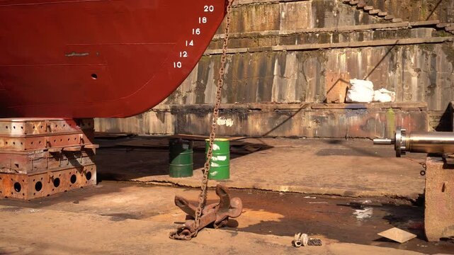 Anchor of ship. Heaving up anchor in dry dock. Vessel ashore on ship repairing yard. Anchor Installation.
