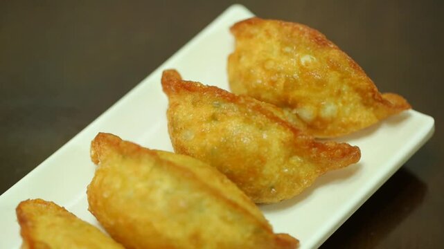 Pan-fried mandu on a white plate