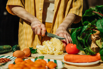 Woman preparing a healthy summer salad with fresh vegetables indoors
