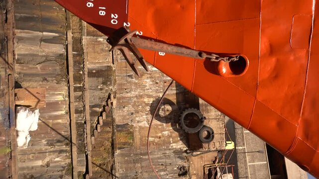 Anchor of ship. Heaving up anchor in dry dock. Vessel ashore on ship repairing yard. Anchor Installation.