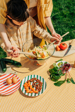 Mother and son preparing a healthy summer salad outdoors