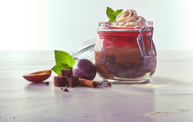 Schokopudding mit Pflaumen und Sahnetupfer in Einmachglas, Obst, Kompott, Pflaumenkompott, Dessert
