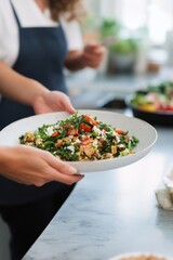 Fresh Healthy Salad Served in Bowl by Person in Professional Kitchen.