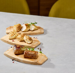 Grilled meat and poultry set with chicken fillet, turkey fillet, pork tenderloin, minimalistic composition, neutral lighting