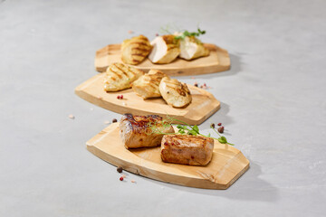 Grilled meat and poultry set, chicken fillet, turkey fillet, pork tenderloin, neutral background, soft natural lighting