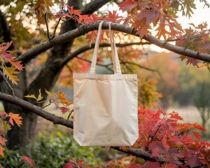 Blank Canvas Tote Bag Displayed on a Tree Branch Surrounded by Vibrant Autumn Leaves