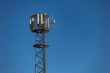 Cellular telephone antenna against a blue sky background,