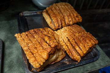 Uncut slabs of crispy pork ready to be divided and served to eat in Thailand