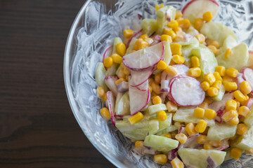 Close-up of a healthy, creamy summer salad served in a transparent glass bowl